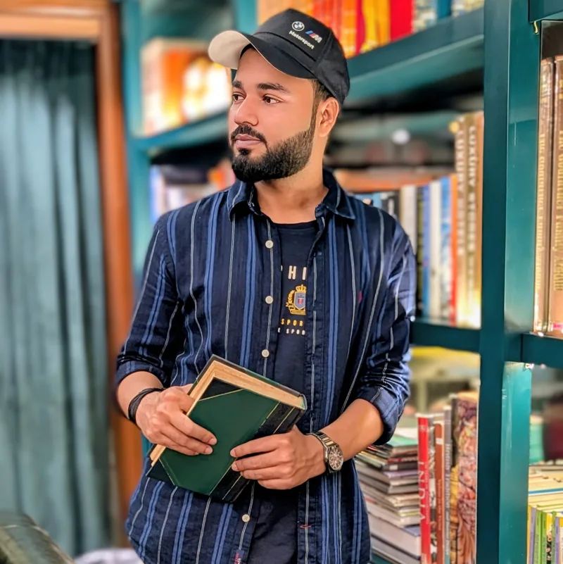 Aakash Kumar holding a book in a library